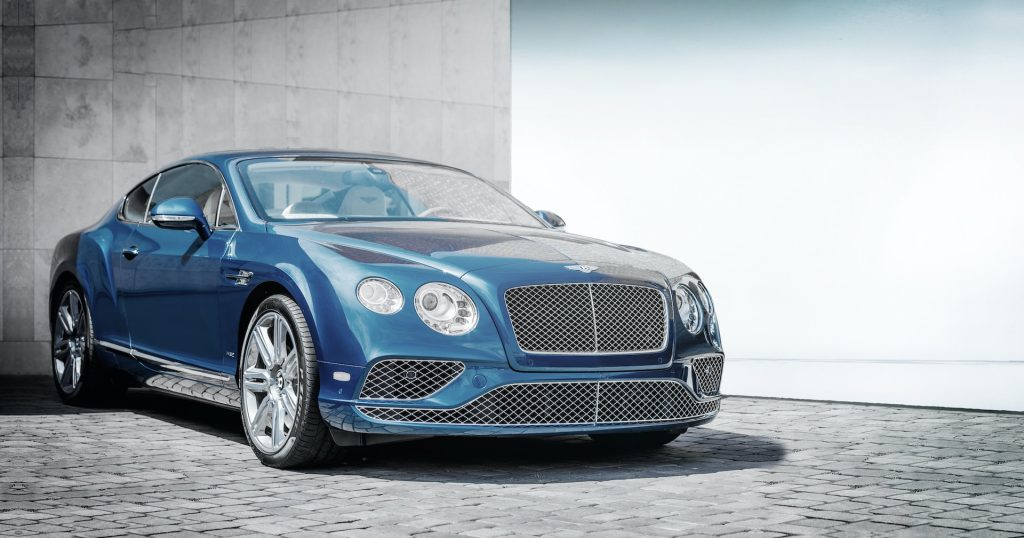 Blue bentley pre-owned luxury car parked on paving